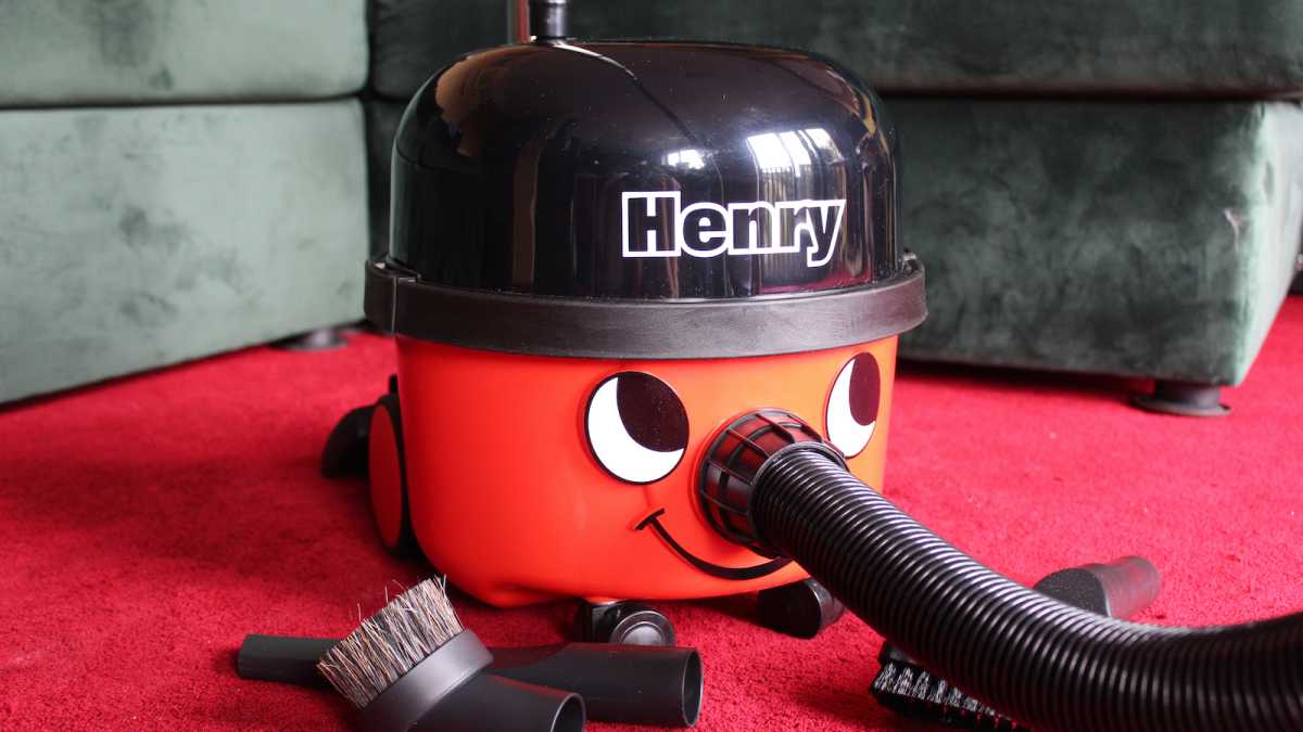 Aspiradora Henry con accesorios en una alfombra roja