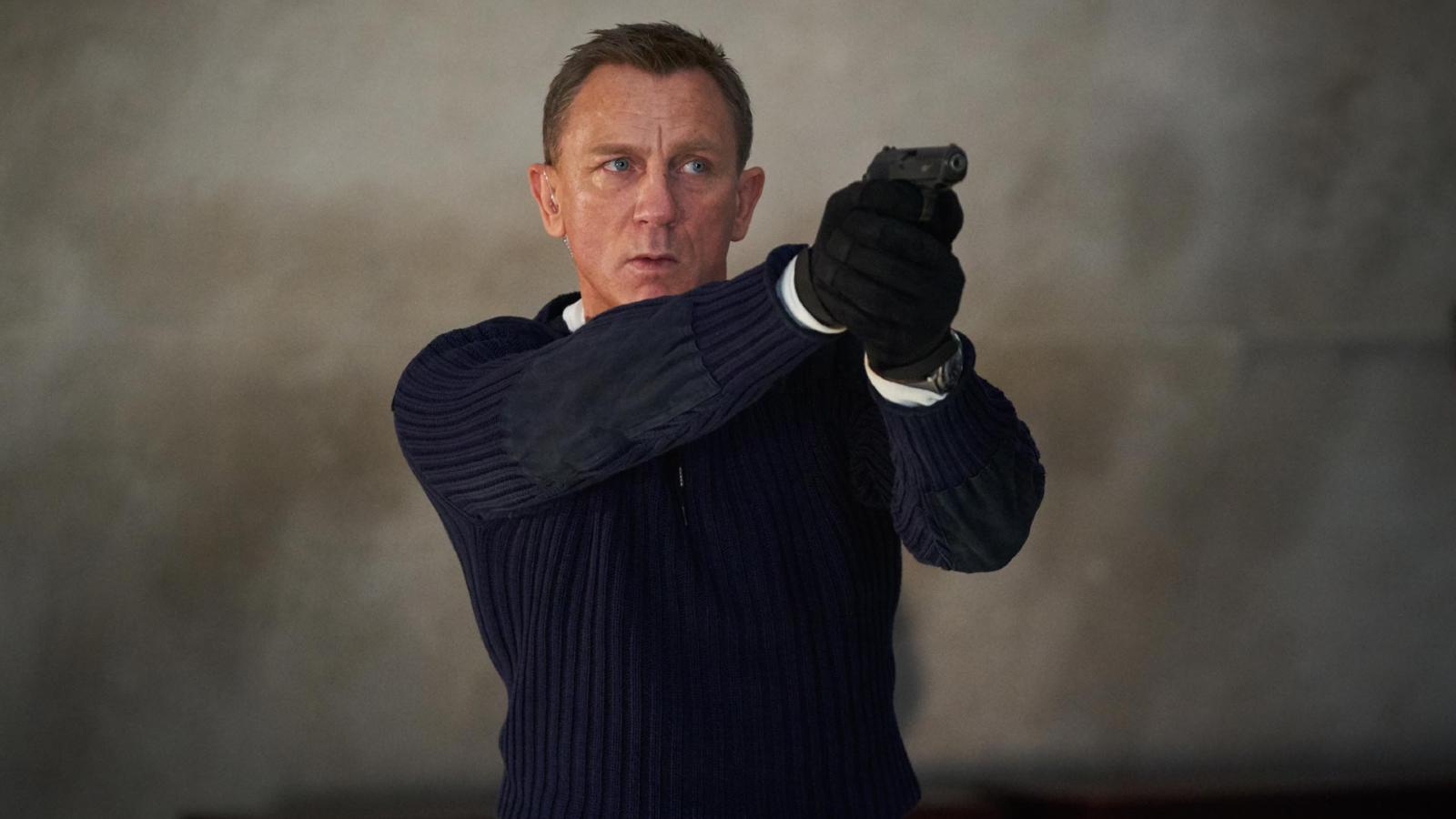 Daniel Craig apuntando con un arma como James Bond en Sin tiempo para morir