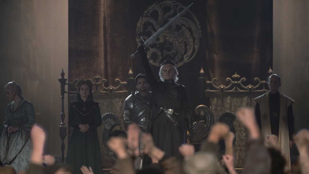 El rey Aegon Targaryen II sostiene una espada mientras es coronado Rey de los Siete Reinos