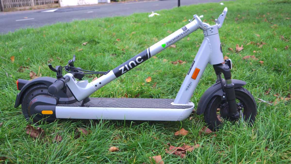 Vista lateral del patinete eléctrico Zinc Velocity Plus doblado sobre el césped